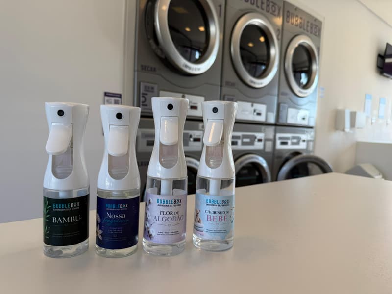 Os quatro frascos de fragrância da casa lado a lado na bancada: Bambu, Nossa Fragrância, Flor de Algodão e Cheirinho de Bebê